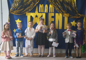Dzieci z grupy 3 pozują do zdjęcia po występie. Zaprezentowały: pokaz gimnastyki artystycznej, pokaz karate, piosenkę, wiersz, grę na pianinie.