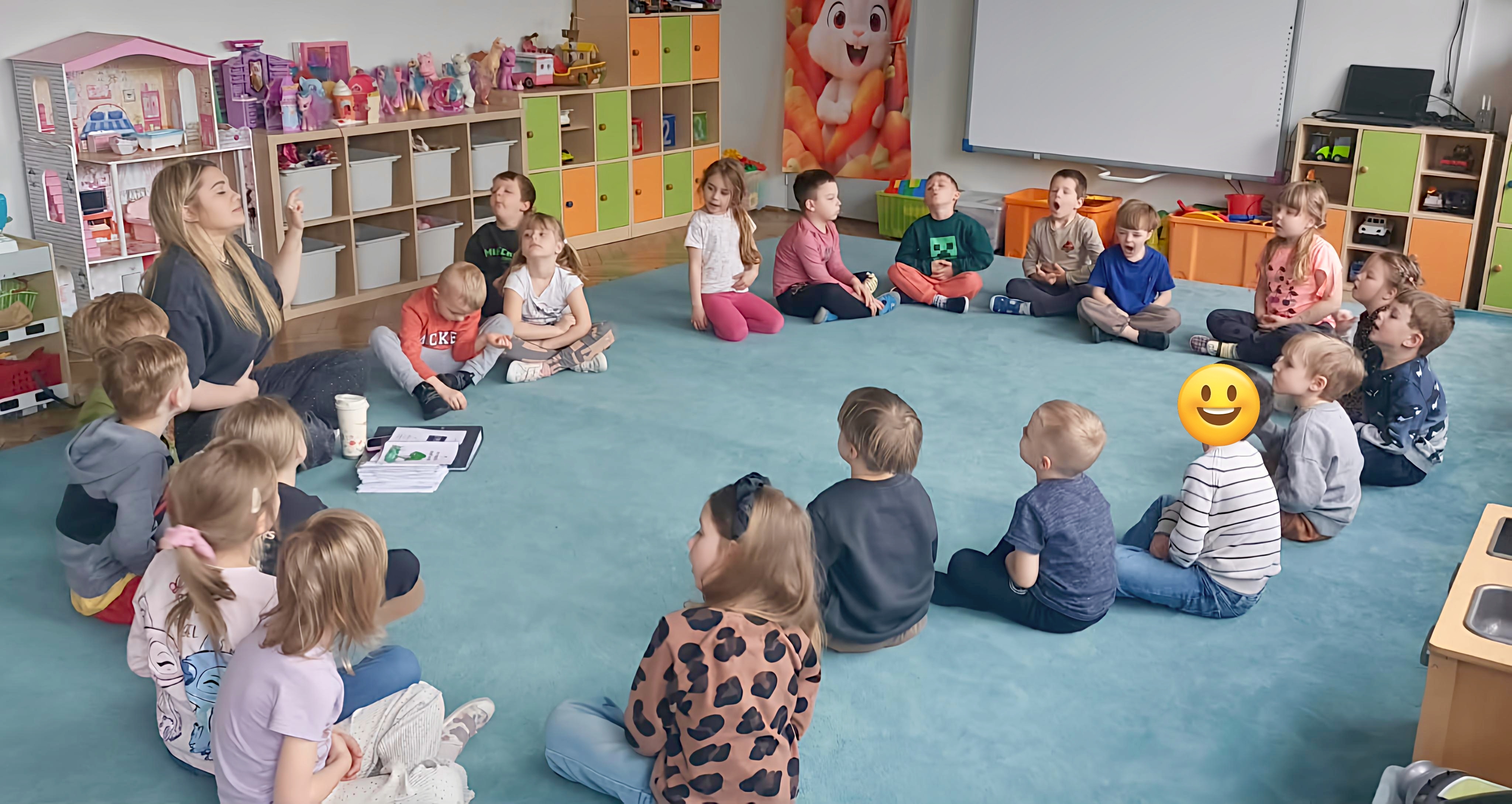 Dzieci i nauczycielka w czasie warsztat&oacute;w o emocjach w grupie 3. Zdjęcie częściowo anonimizowane.