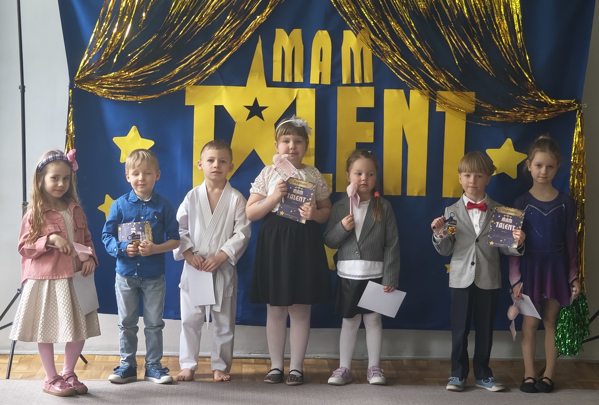 Dzieci z grupy 3 pozują do zdjęcia po występie. Zaprezentowały: pokaz gimnastyki artystycznej, pokaz karate, piosenkę, wiersz, grę na pianinie.