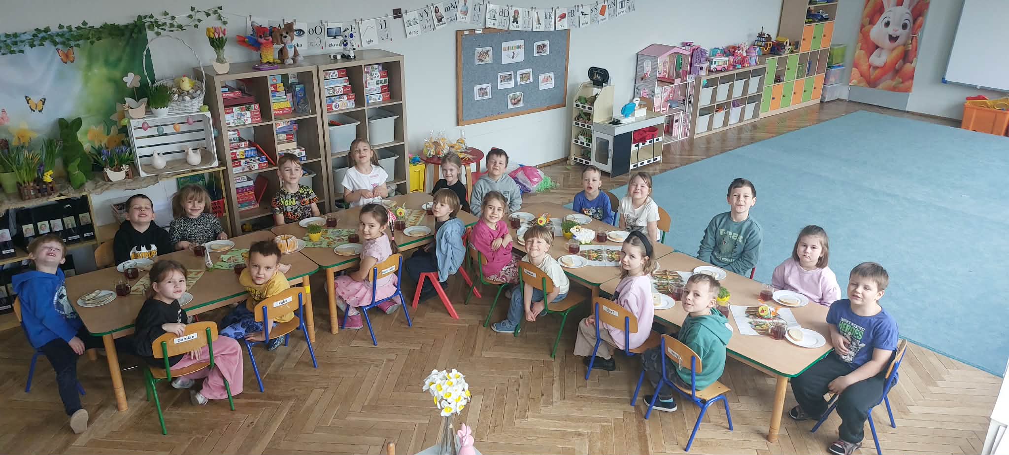 Dzieci z grupy 3 i 5 siedzą przy wspólnym stole wielkanocnym.