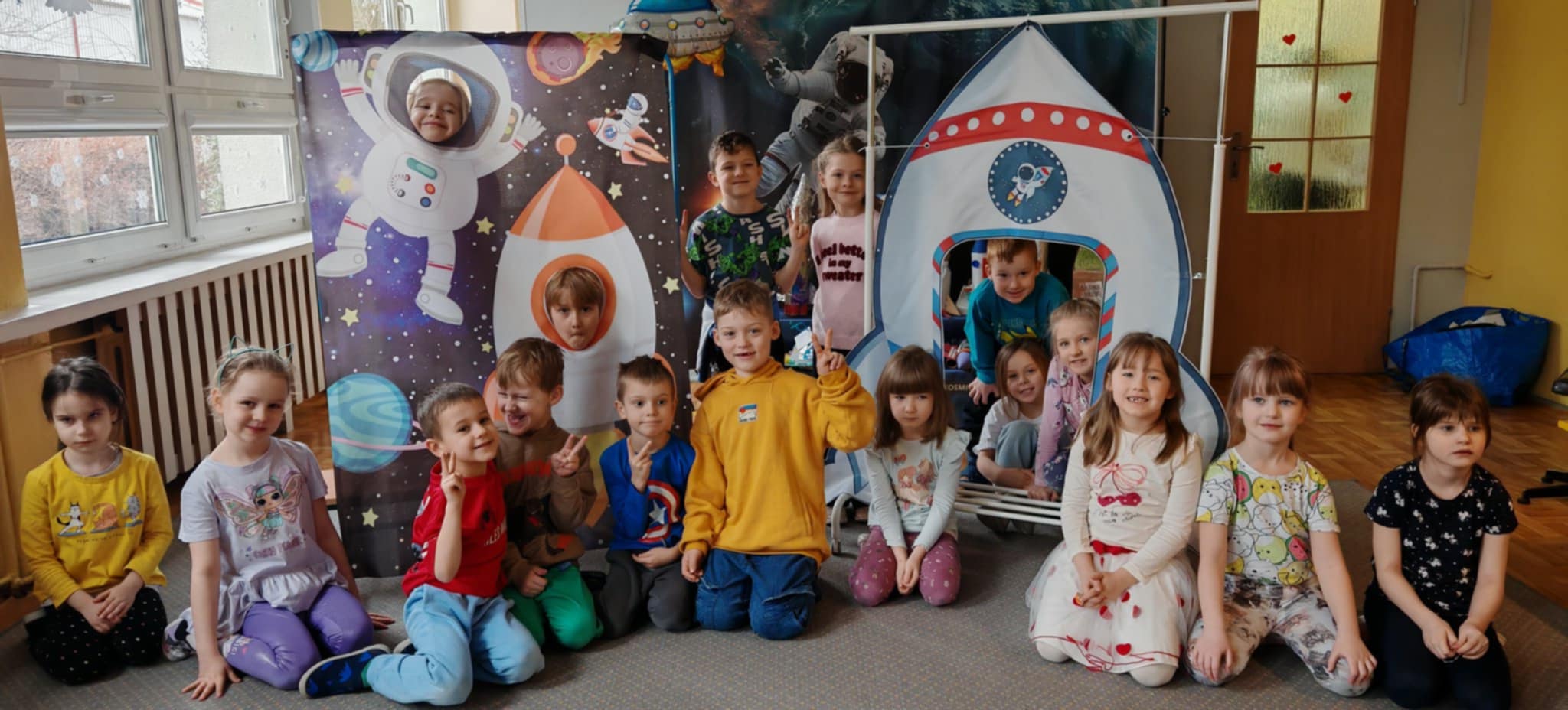 Grupa dzieci pozuje do wspólnego zdjęcia w otoczeniu "kosmicznych" dekoracji. Grupa 4
