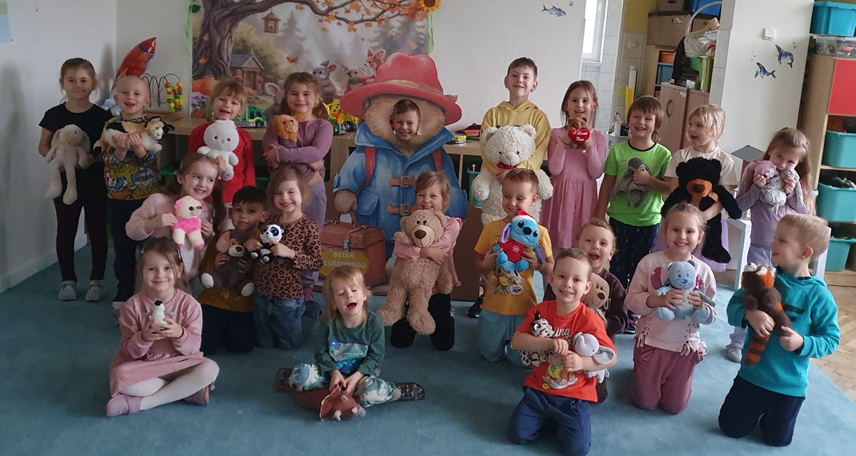 Dzieci pozują do wspólnego zdjęcia trzymając ukochane pluszowe misie.