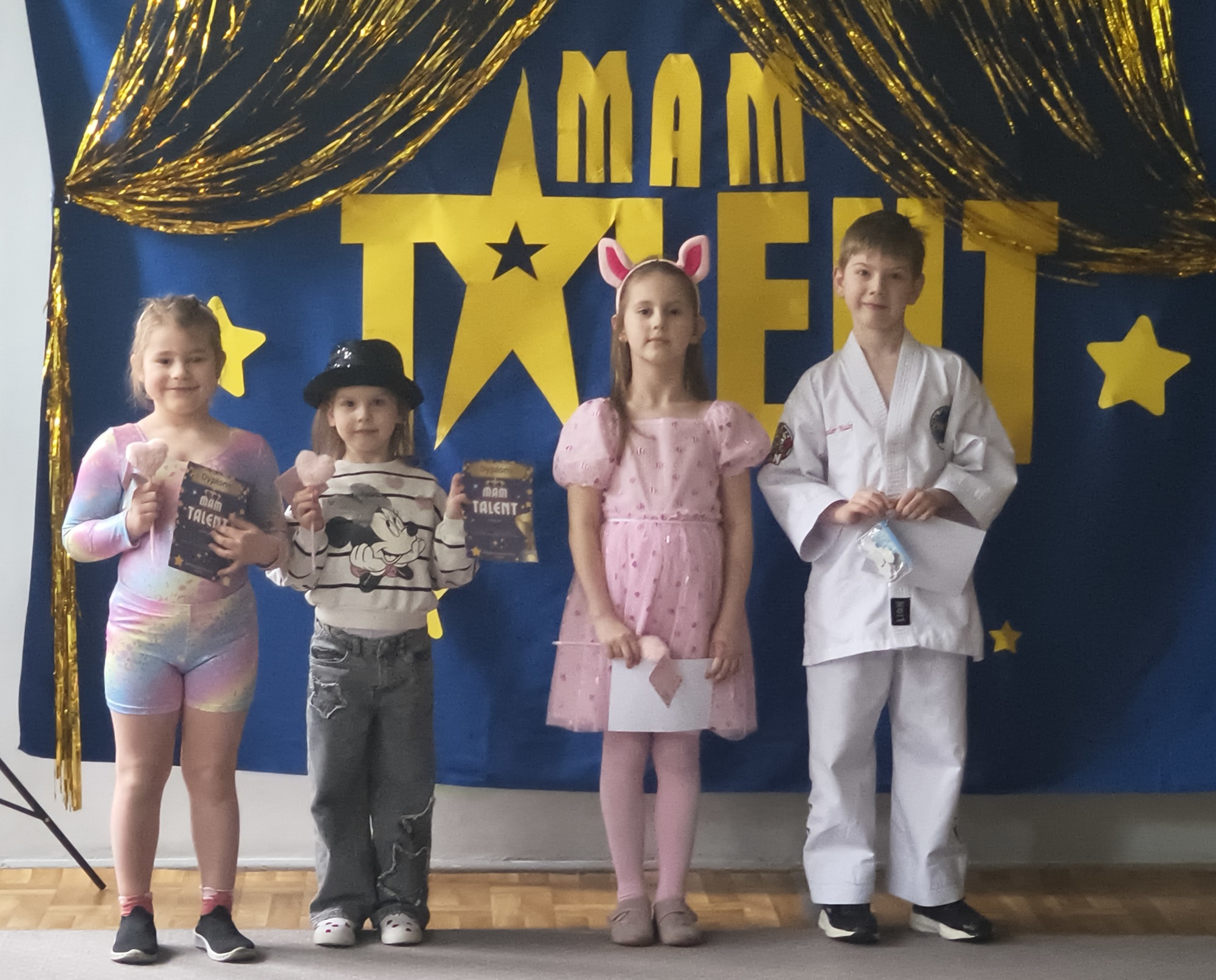 Dzieci z grupy 5 pozują do zdjęcia po występie. Zaprezentowały: gimnastykę artystyczną, wiersze i pokaz taekwondo.