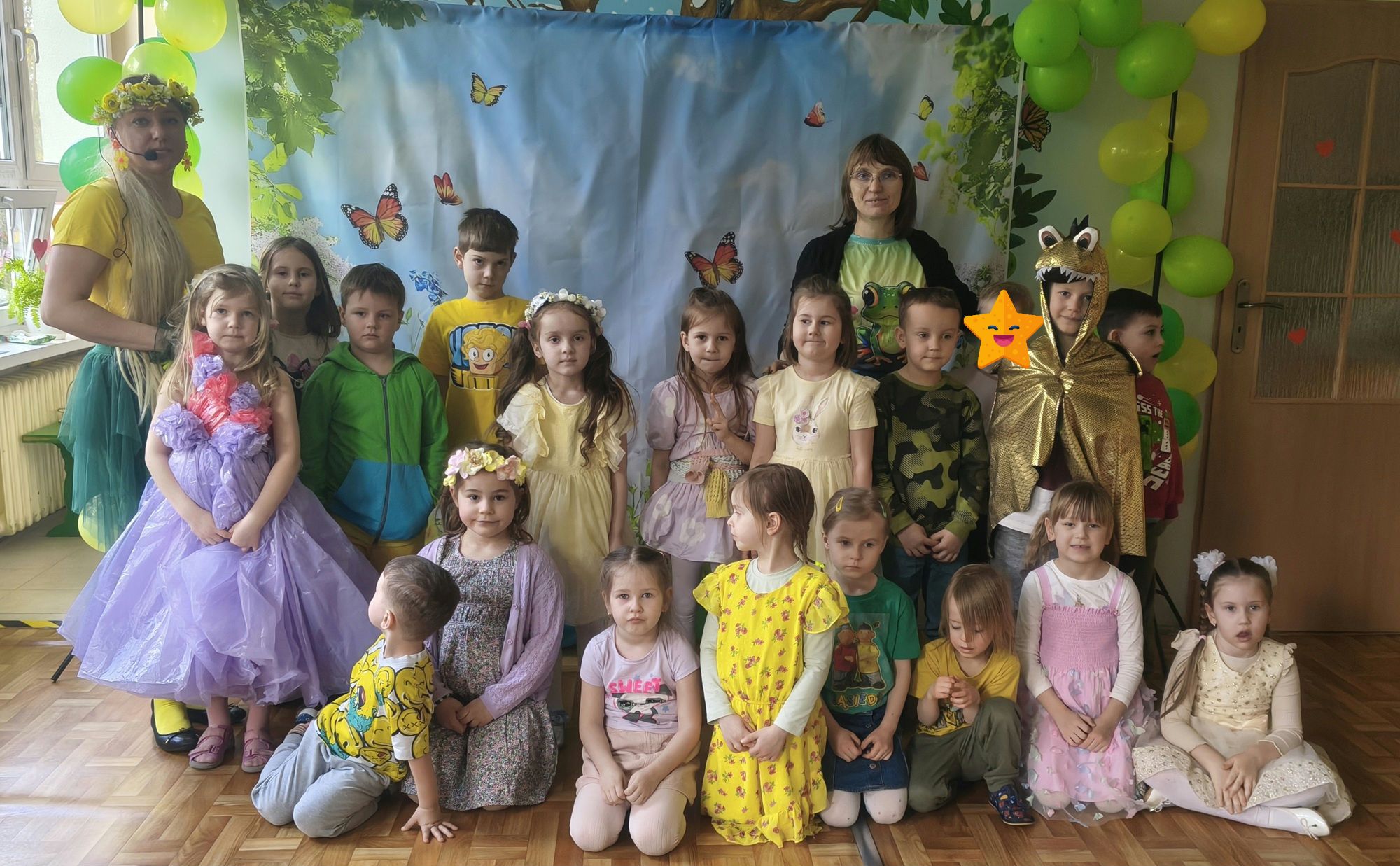 Dzieci i nauczyciele z grupy 5 pozują do wsp&oacute;lnego zdjęcia na balu wiosny.