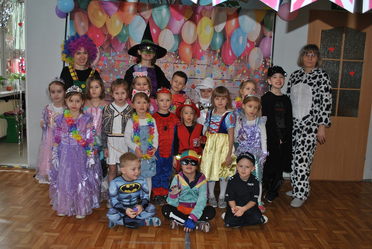 Dzieci w przebraniach karnawałowych pozują do wsp&oacute;lnego zdjęcia. Grupa 5