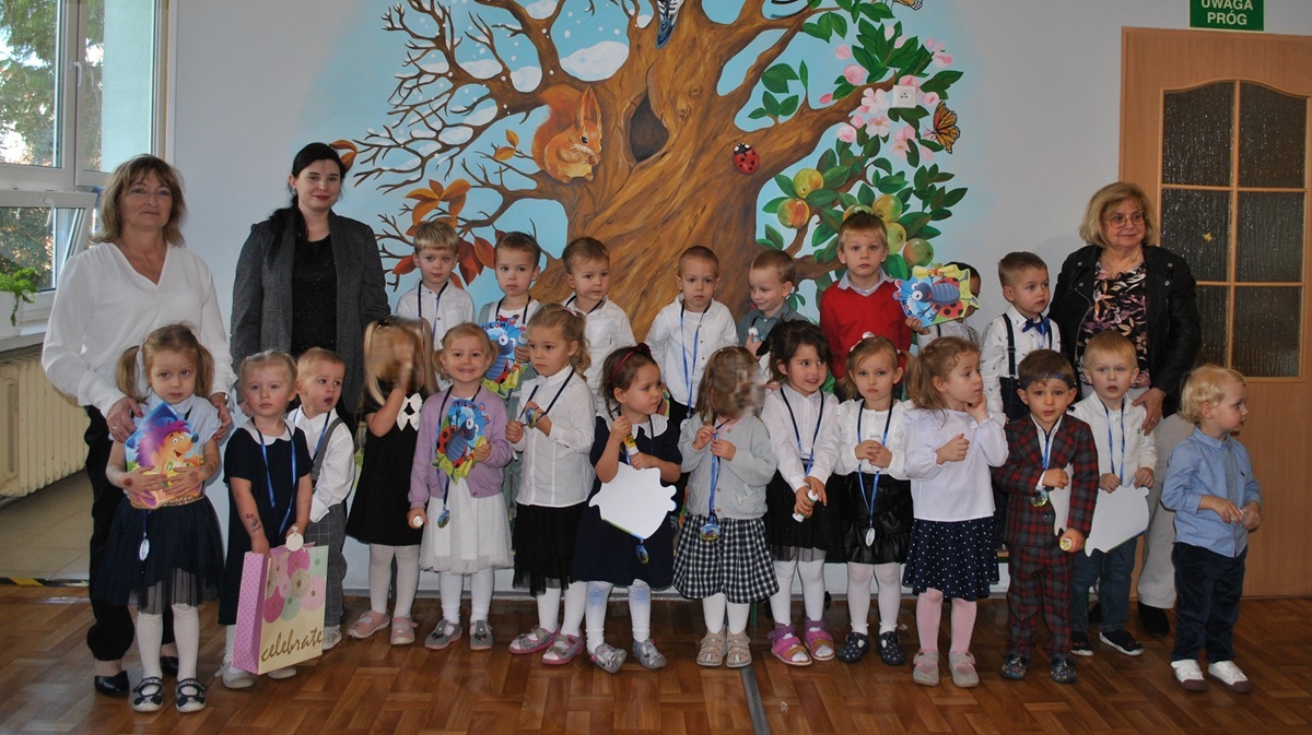Dzieci i nauczycielki pozują do wsp&oacute;lnego zdjęcia z okazji "Pasowania na przedszkolaka".