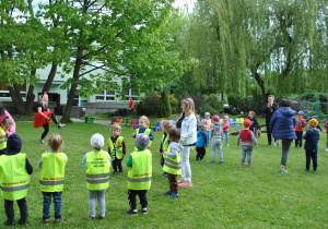 Dzieci tańczą w ogrodzie. Nauczyciele tańczą razem z dziećmi.