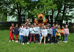 Grupa dzieci pozuje do wspólnego zdjęcia z dużą maskotką Scooby-Doo.
