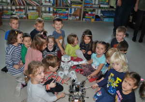 Grupa dzieci pozuje do zdjęcia z robotami. Ujęcie 2