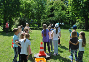Dzieci ustawione w dwóch rzędach do wyścigów. Ujęcie zza grupy dzieci.