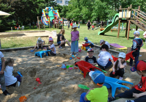 Dzieci podczas zabawy w piaskownicy. Szerokie ujęcie.