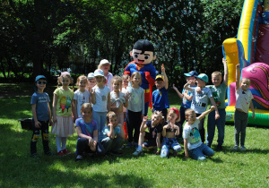 Dzieci z grupy 4 pozują do wspólnego zdjęcia z maskotką - supermenem i nauczycielką.