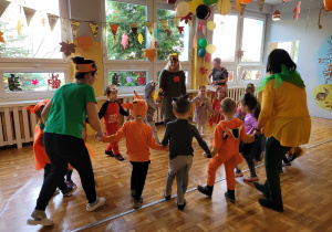 Dzieci tańczą z nauczycielkami trzymając się za ręce.