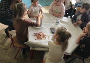 Dzieci i rodzice przygotowują różne sałatki.