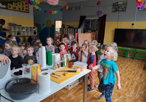 Dzieci na widowni i widok na stanowisko kucharskie.