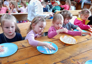 Dzieci przygotowują się do zagniatania ciasta chlebowego.