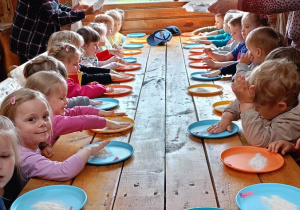 Dzieci przygotowują się do zagniatania ciasta chlebowego.