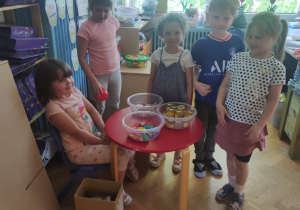 Dzieci w grupie cieszą się z otrzymanych słodyczy.