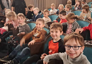 Dzieci siedzą na widowni w teatrze.