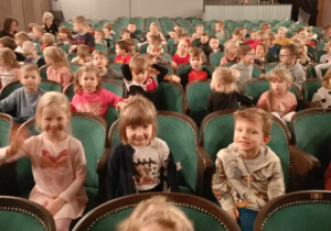 Dzieci siedzą na widowni w teatrze.
