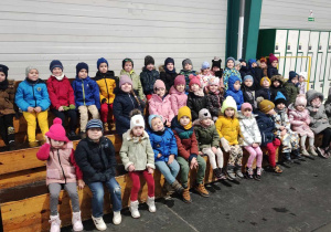 Pierwsza wizyta na lodowisku i omówienie zasad bezpieczeństwa. Dzieci siedzą na trybunie.