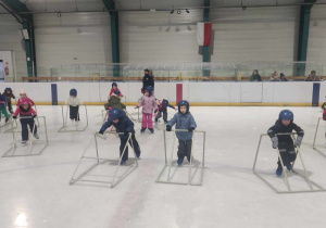 Dzieci uczą się jeździć na łyżwach.