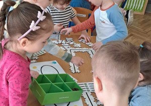 Dzieci kodują drogę dla Ozobota przy użyciu ruchomych puzzli.