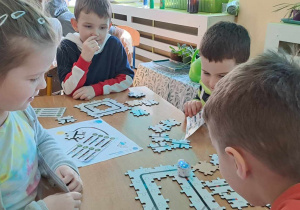 Dzieci kodują drogę dla Ozobota przy użyciu ruchomych puzzli.
