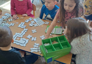 Dzieci uczą się kodowania z puzzlami do robota edukacyjnego Ozobot.