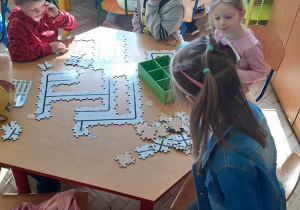Dzieci uczą się kodowania z puzzlami do robota edukacyjnego Ozobot.