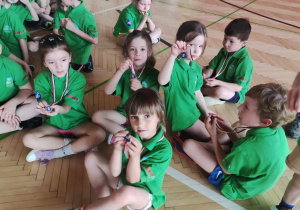 Dzieci odpoczywają po zdobyciu medali.