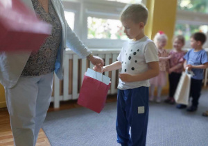 Dzieci odbierają dyplomy i nagrody z rąk dyrektora przedszkola.