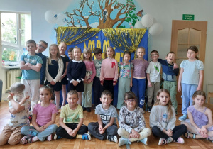 Grupa dzieci pozuje do wspólnego zdjęcia na tle napisu "Mam talent".