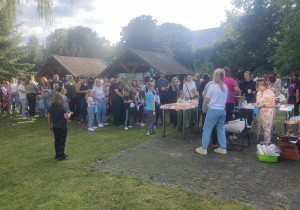 Uczestnicy pikniku stoją w kolejce po słodkie wypieki.
