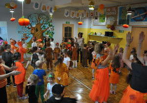 Dzieci i nauczyciele wspólnie bawią się na balu jesieni. Uczestnicy balu są poprzebierani w stroje związane z tematyką imprezy. Ujęcie 3