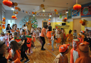 Dzieci i nauczyciele wspólnie bawią się na balu jesieni. Uczestnicy balu są poprzebierani w stroje związane z tematyką imprezy. Ujęcie 4