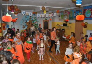 Dzieci i nauczyciele wspólnie bawią się na balu jesieni. Uczestnicy balu są poprzebierani w stroje związane z tematyką imprezy. Ujęcie 5