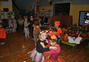 Dzieci i nauczyciele wspólnie bawią się na balu jesieni. Uczestnicy balu są poprzebierani w stroje związane z tematyką imprezy. Ujęcie 6