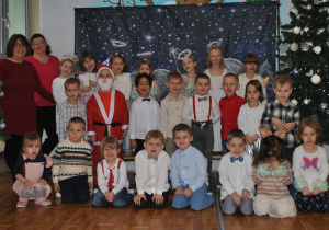 Dzieci z grupy 2 pozują do wspólnego zdjęcia po przedstawieniu świątecznym.