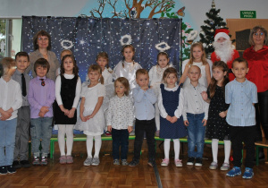 Dzieci z grupy 5 pozują do wspólnego zdjęcia po przedstawieniu świątecznym.