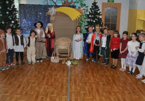 Dzieci z grupy 4 pozują do wspólnego zdjęcia po przedstawieniu świątecznym.