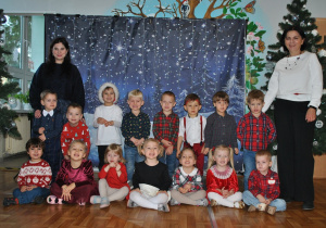 Dzieci z grupy 1 pozują do wspólnego zdjęcia po przedstawieniu świątecznym.