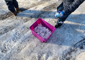 Grupa dzieci zbiera kawałki lodu z parkingu. Ujęcie 3
