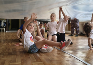 Dzieci schowane pod baldachimem z folii.