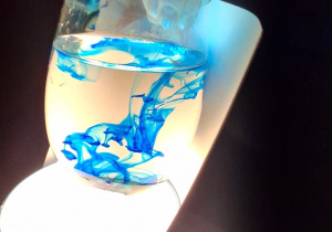 Szklanka wody z niebieskim barwnikiem.