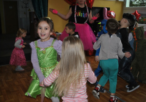 Bal karnawałowy. Dzieci i nauczyciele w przebraniach karnawałowych wspólnie tańczą. Ujęcie 4