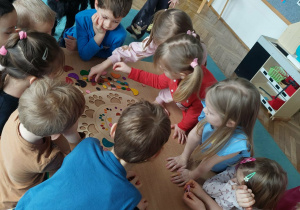 Grupa dzieci w czasie zabawy stolikowej.