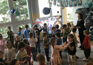 Dzieci tańczą razem z nauczycielką. Ujęcie 2