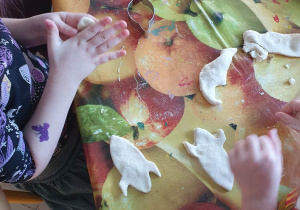 Dzieci lepią ciasteczka w kształcie rakiet kosmicznych.