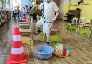 Dzieci w czasie zajęć ruchowych pokonują przeszkody.